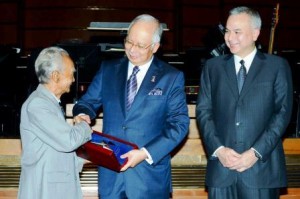 Soepadmo (left) receiving the award presented by Najib (middle) while Raja Dr Nazrin (right) looks on.